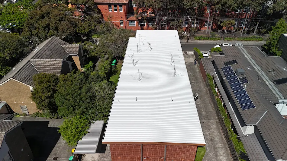 Heat reflective coating applied to commercial roof in Kew for improved comfort and efficiency.