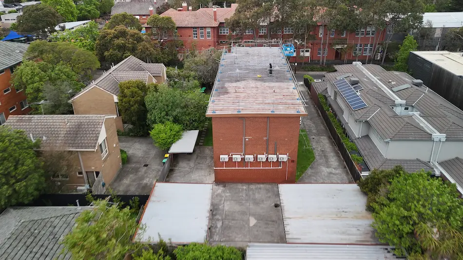 MPC team pressure washing a Kew commercial roof to remove dirt and rust before painting.