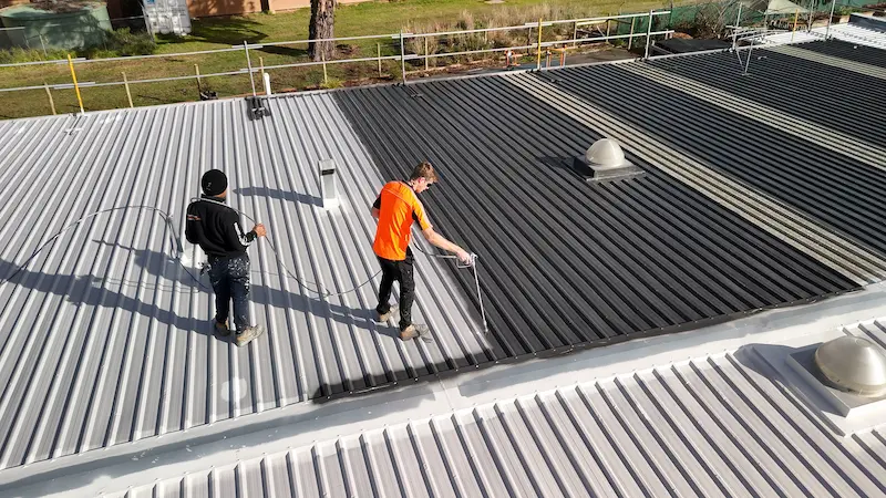 Lilydale School roof receiving topcoat for long-term waterproofing and leak repair