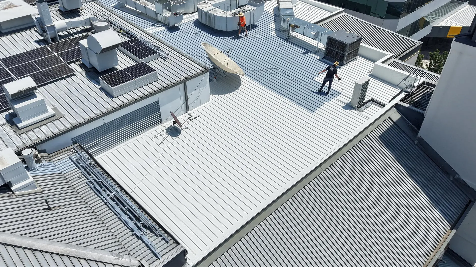 Roof preparation and coating works underway with solar panels and plant equipment in place